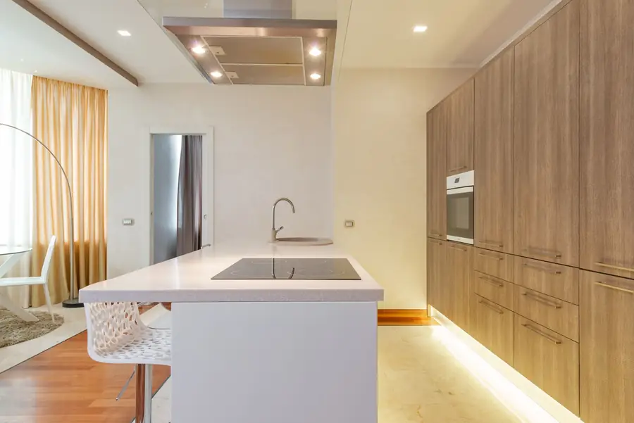 Witte keuken met een eiland en kasten in licht hout
