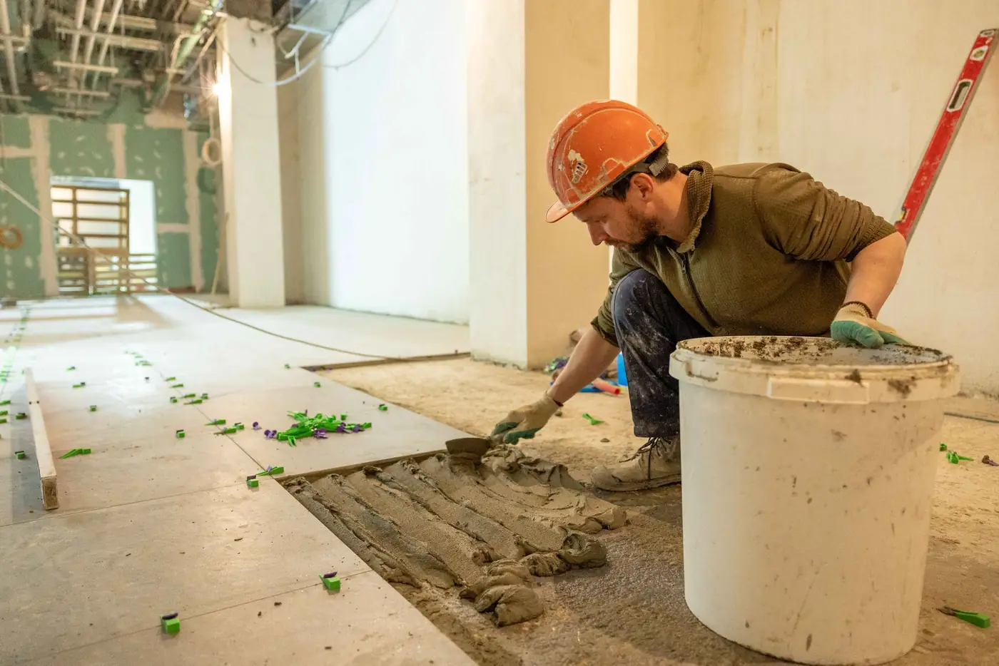 Vakman legt een nieuwe vloer in een woning in renovatie