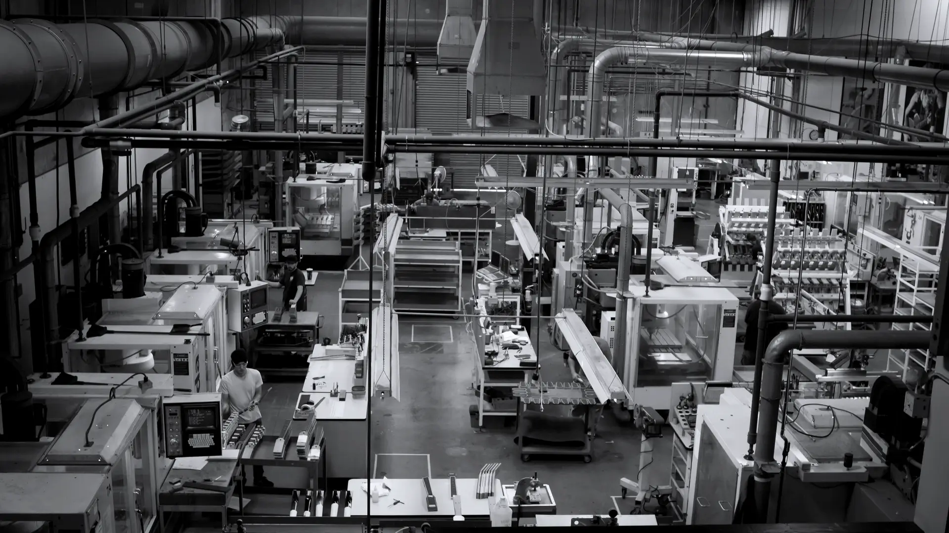 Een productiehal met rijen CNC-freesmachines en afzuiging aan het plafond