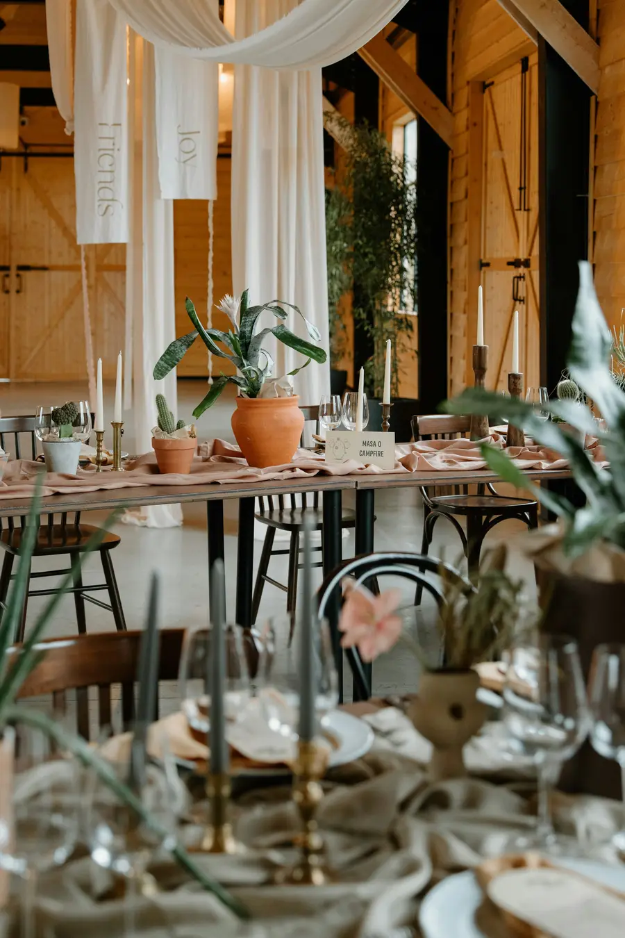 Gedekte tafel met smalle kaarsen, terracotta potten en planten