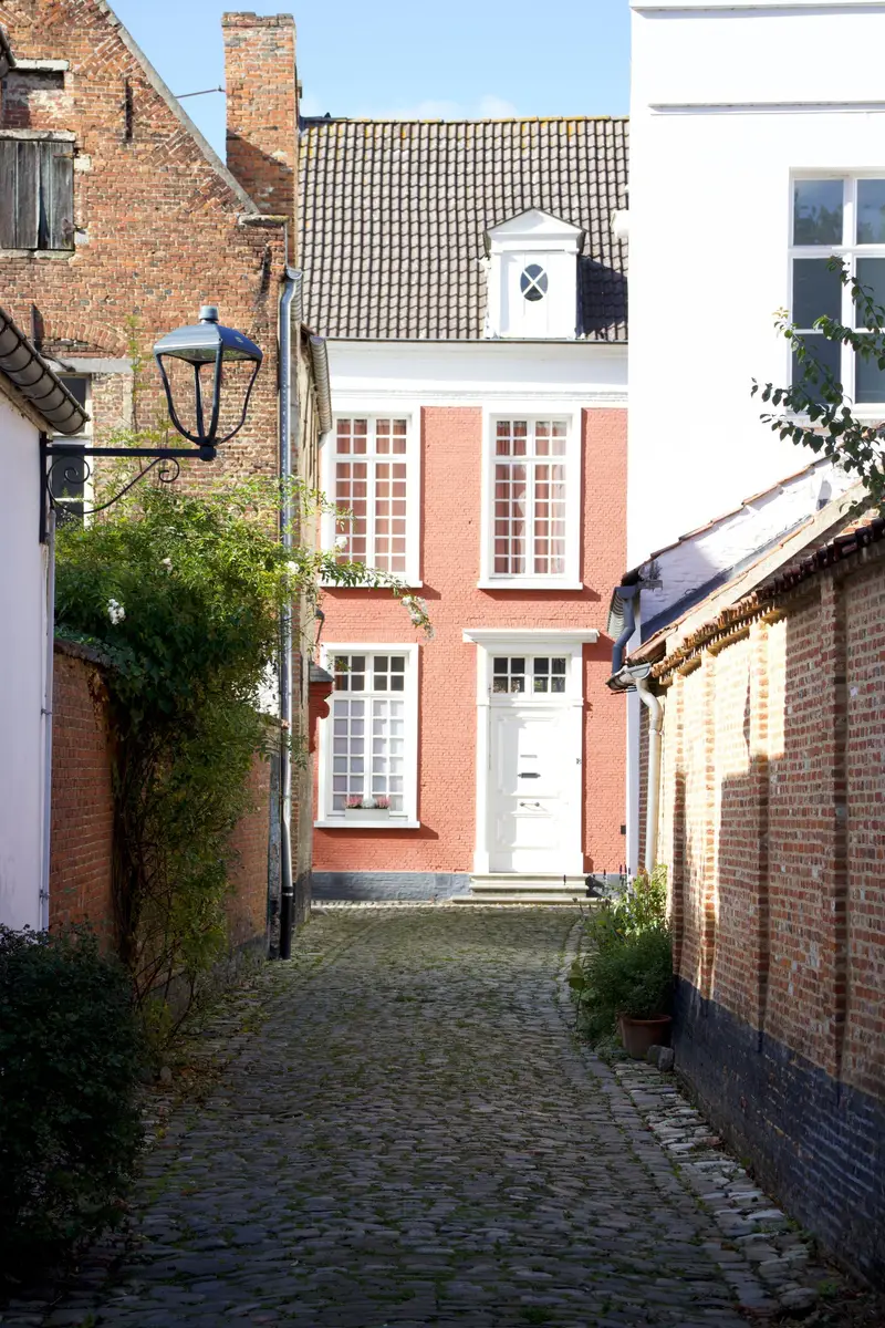 Herenhuis met witte ramen aan een kasseisteegje