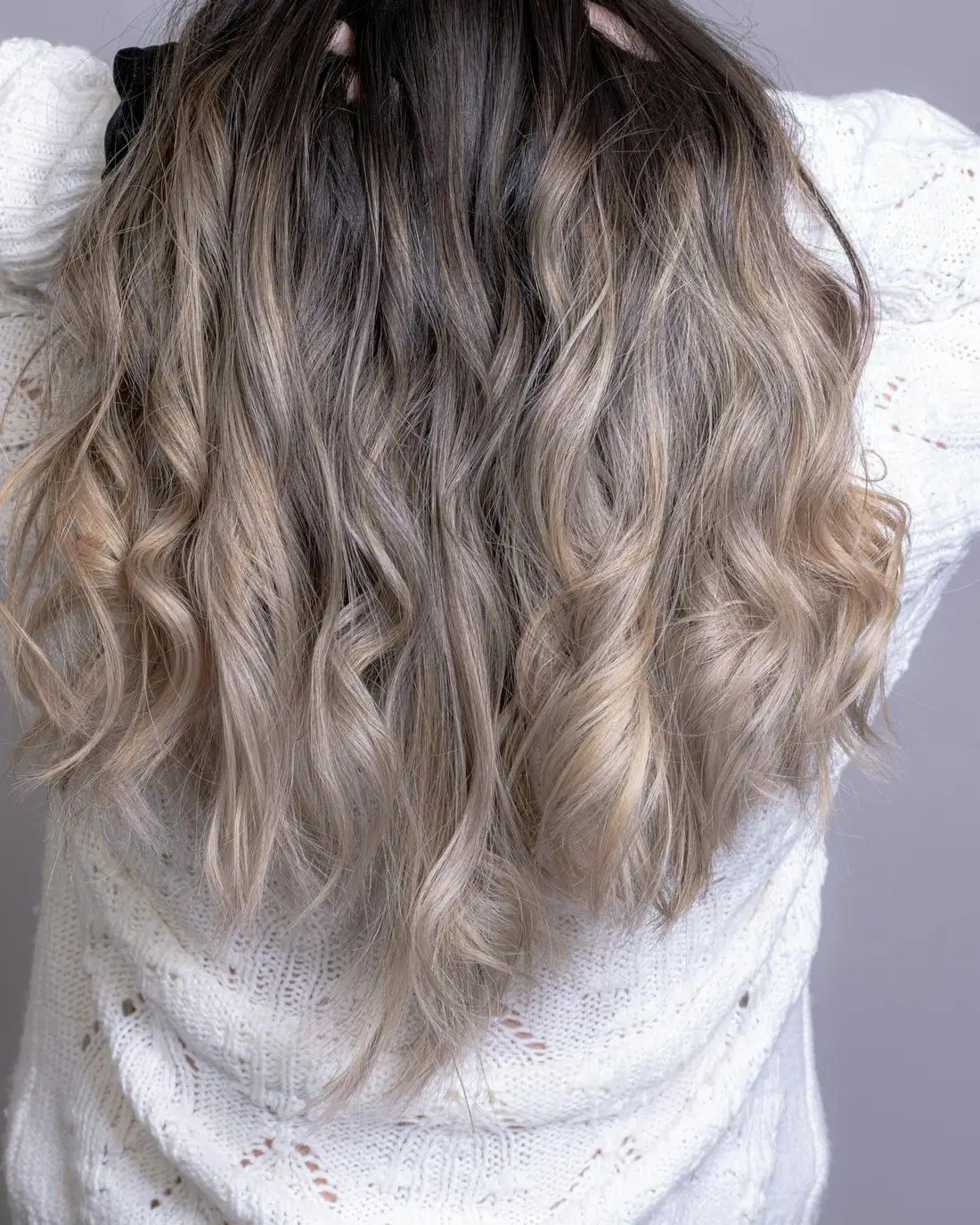 Golvend haar met een koele asblonde ombré, van achteren