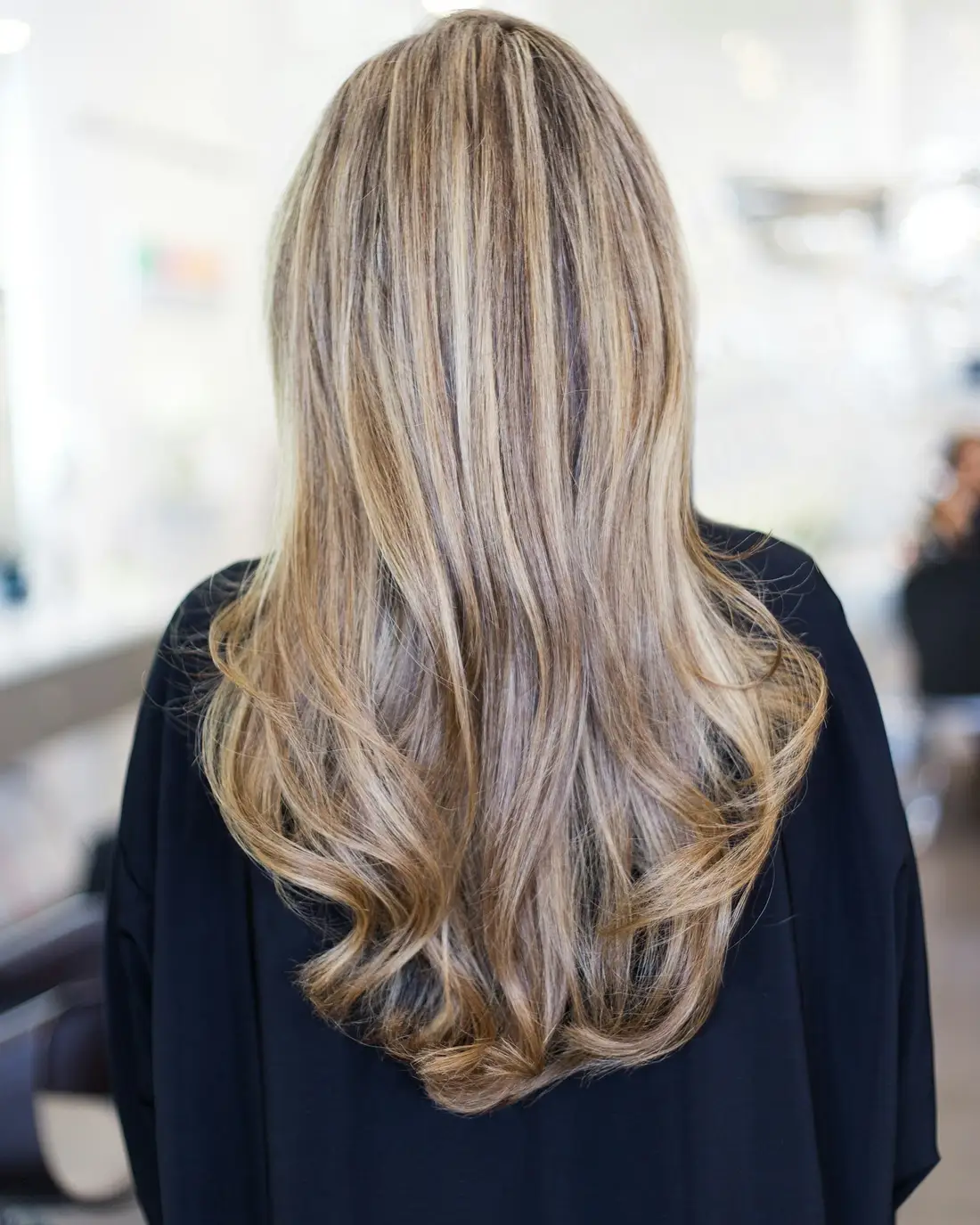Lang golvend haar met een zachte balayage van bruin naar blond, van achteren