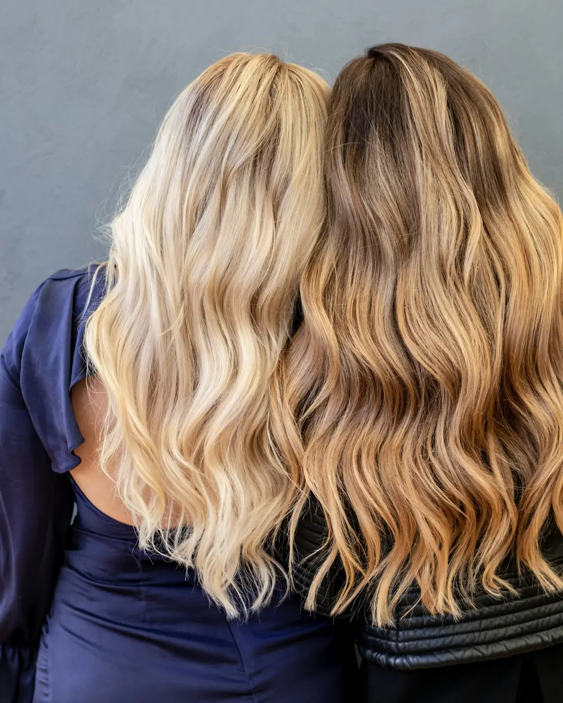 Twee vrouwen met lang golvend blond en goudblond haar, van achteren