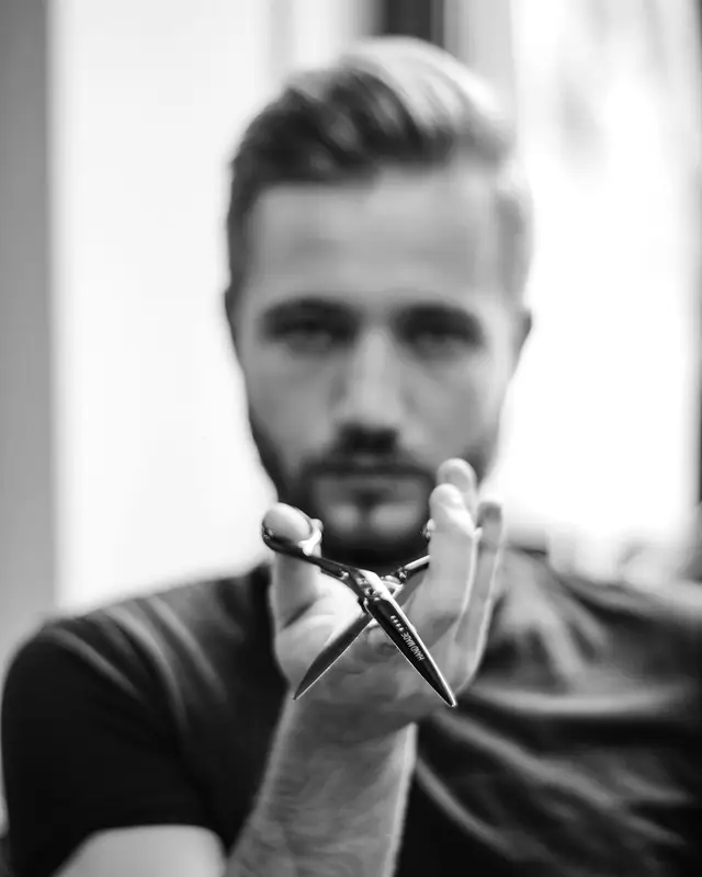 Portret van kapper Ruben met een schaar in de hand